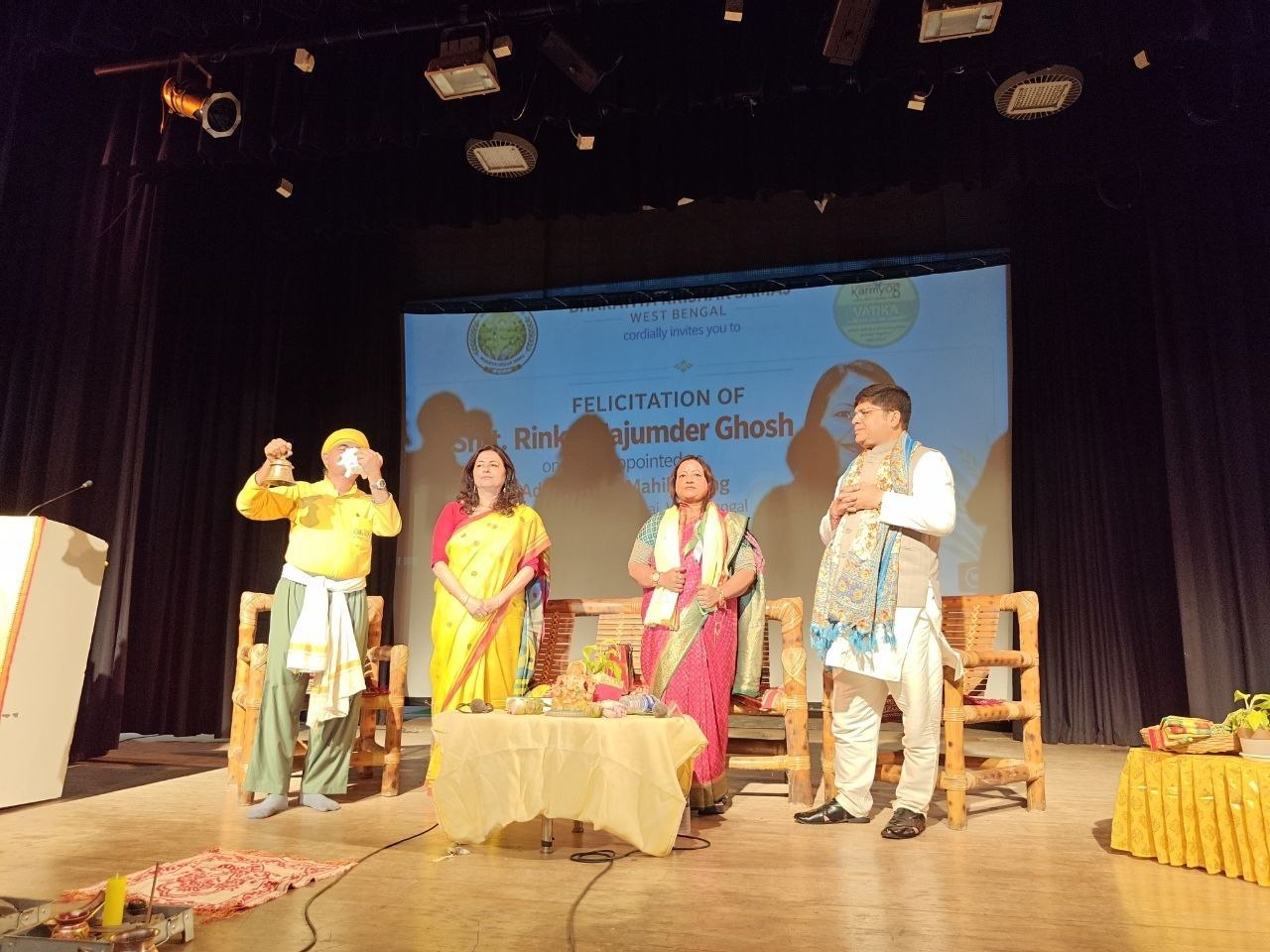 Standing for the felicitation, bell in hand